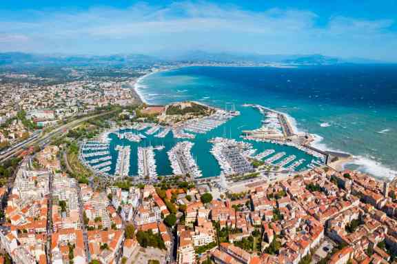View of Antibes from above looking over the city, harbor full of yachts and the blue water.