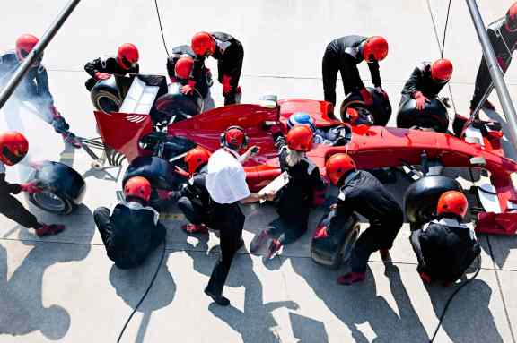Formula 1 Grand Prix Pit crew prepping red formula one race car