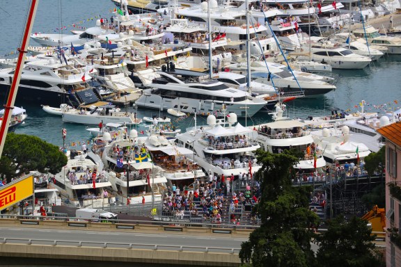 People watching the Monaco Formula 1 Grand Prix from the back of their yachts in Monaco harbour.